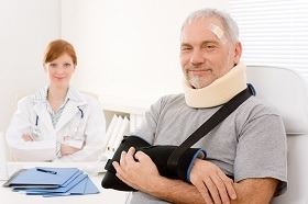man in a sling and neck brace being treated by a doctor