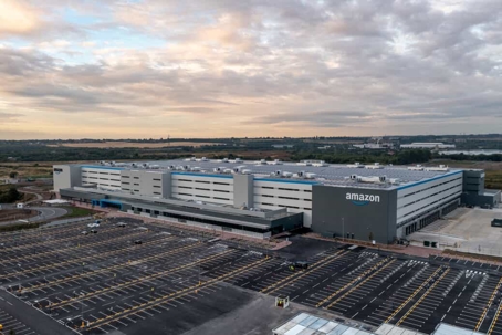Amazon warehouse from above on a partly cloudy day around sunrise